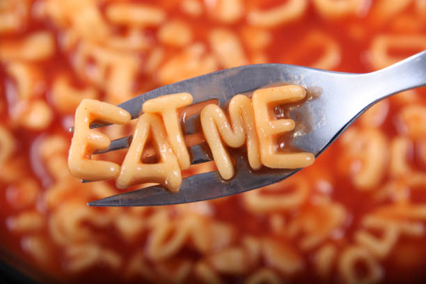 Spaghetti letter spelling the word 'Eat Me' with the letters held up on a fork. Spaghetti letter spelling the word 'Eat Me' with the letters held up on a fork. carbohydrate food type stock pictures, royalty-free photos & images