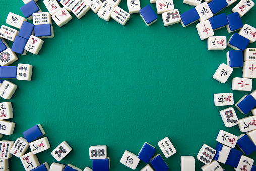 A game of mahjong being played on a mahjong table.