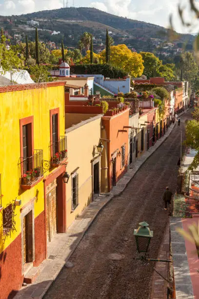 A colorful quiet street on a sunny afternoon over looking the mountain, San Miguel de Allende, Mexico