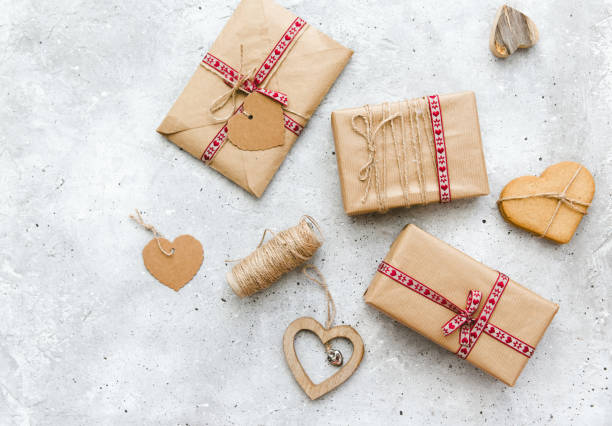 istock Gift wrapped boxes and red decorative heart on vintage background. Flat lay composition 898802730
