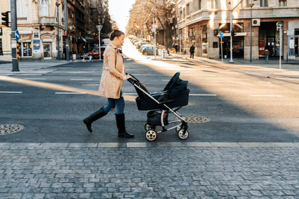istock Mother pushing a stroller in the street 898802924
