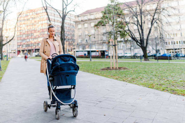 istock Mother pushing a stroller in the park 898802982