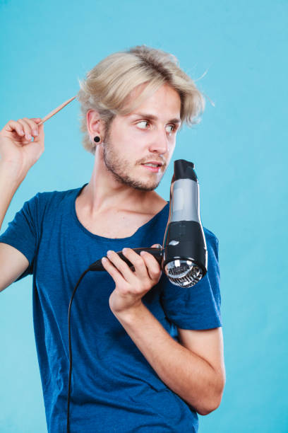 istock Trendy man with hair dryer 898813360