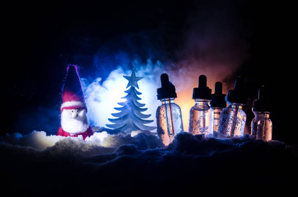 istock Electronic cigarette with vape liquids and christmas decorations on bokeh lights background 898818524