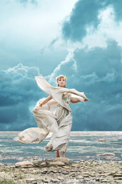 woman and fresh sea breeze woman in the costume of a nymph standing on the beach in the wind goddess of ocean stock pictures, royalty-free photos & images