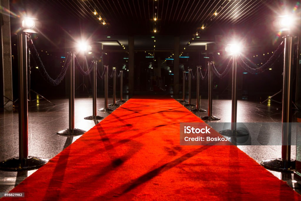 Red carpet Long red carpet between rope barriers on entrance. Premiere Event Stock Photo