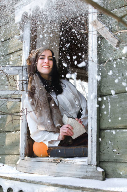 Gypsy laughs snowfall while looking out the window of an abandoned house