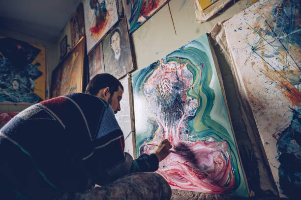 istock Artist working on a painting in studio 898826144