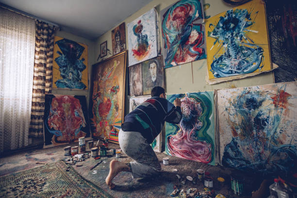 istock Young man working on a painting in studio 898826308