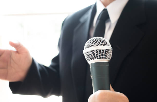 istock Journalists filing microphone interviewing to businessman. Smart Reporter taking interview and speech with microphone at presentation in conference, Business seminar concept 898828860