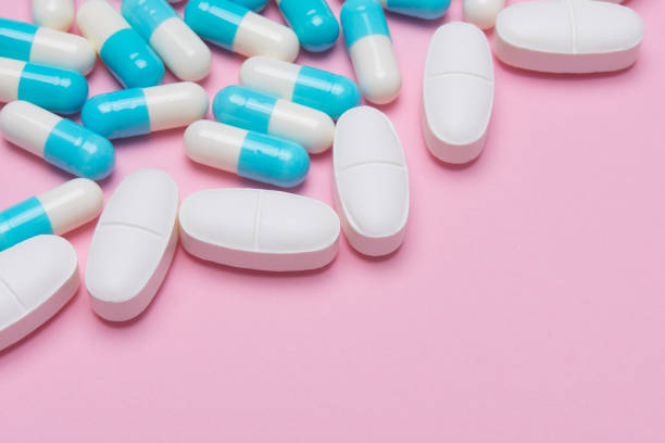 istock tablets and capsules of medicine on pink background 898830502