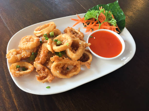 Fried squid rings with hot spicy sauce Fried squid rings with hot spicy sauce. calamari photos stock pictures, royalty-free photos & images