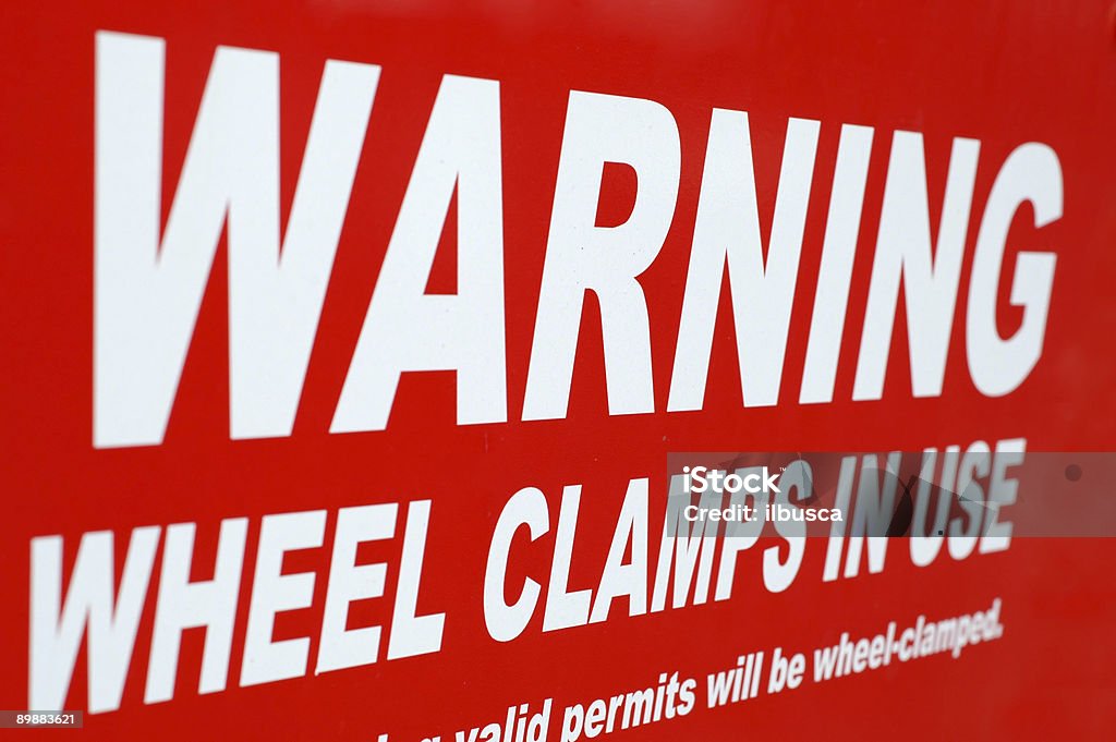 Warning wheel clamps in use sign Warning wheel clamps in use sign. Close-up Stock Photo