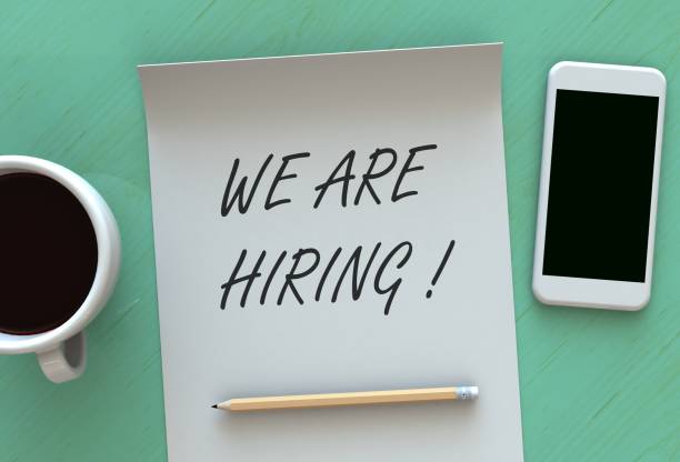 istock WE ARE HIRING, message on paper, smart phone and coffee on table 898842022