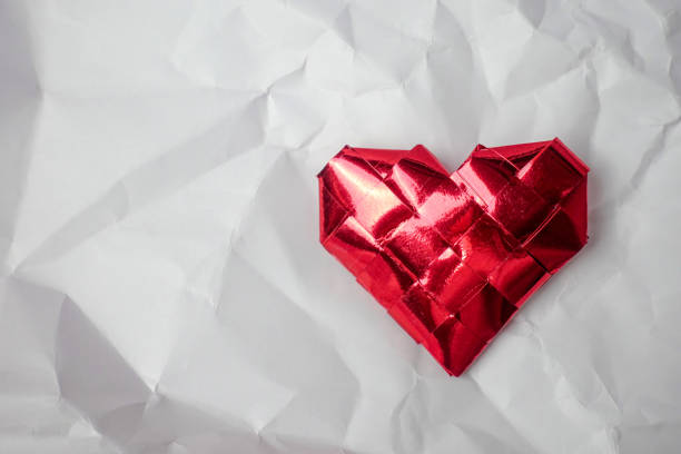 istock Red heart on white crumpled paper background 898842738