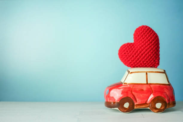 istock Miniature red car carrying a red heart 898842772