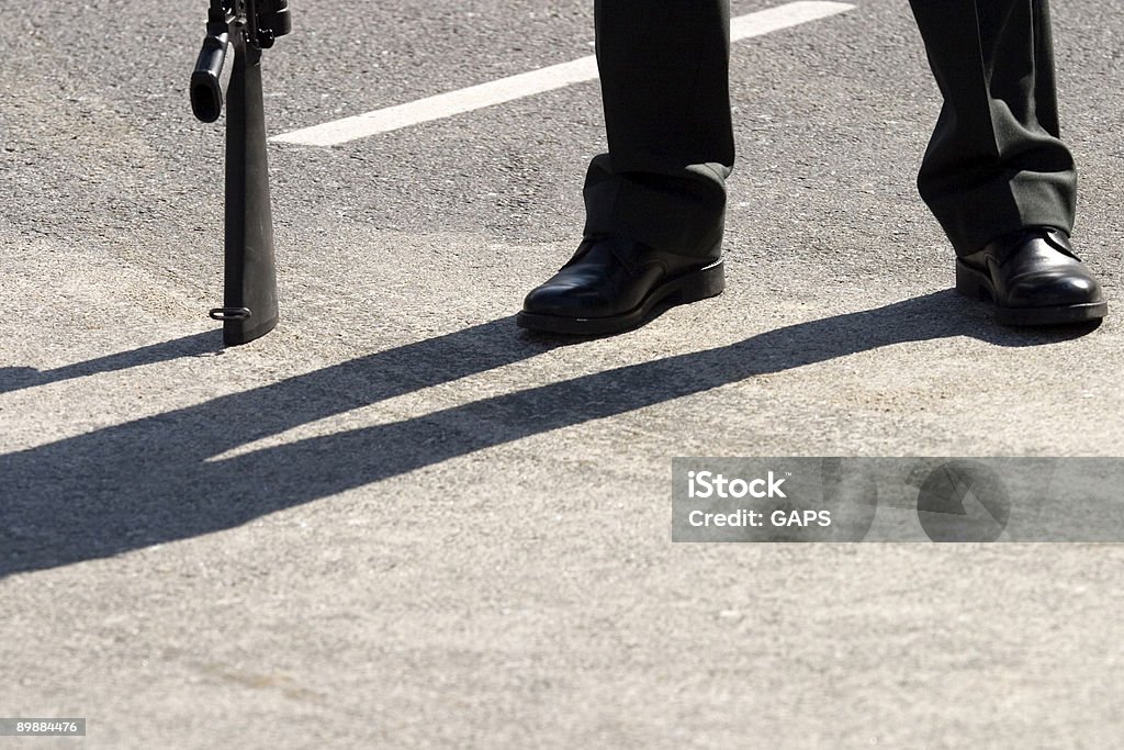 Nicht erkennbare guard mit seiner Waffe ruhen auf dem Boden - Lizenzfrei Asphalt Stock-Foto