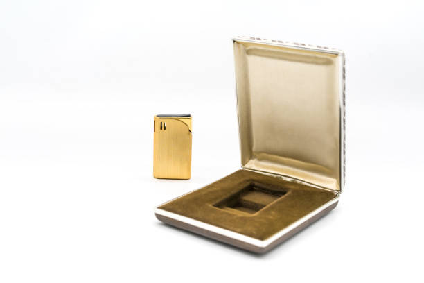 Vintage gold cigarette lighter with luxury brown and gold packaging isolated on white background