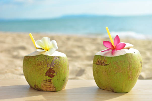 istock Coconut fruit with flower on wood table with blue sea and sky background 898848836