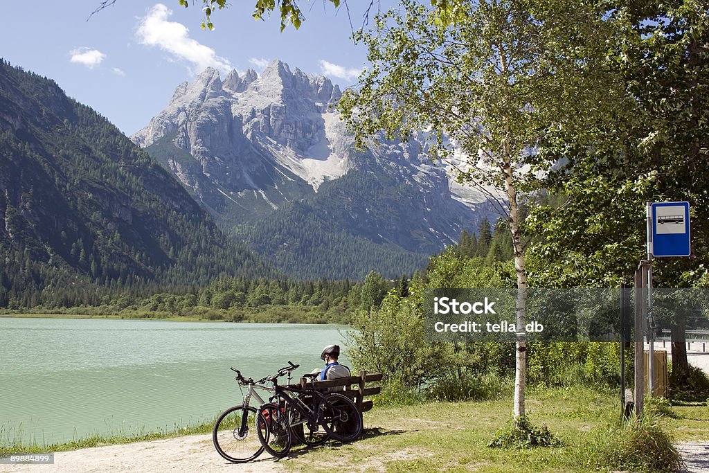 Motociclista sentado en frente de beatiful alpes dolomíticos vista - Foto de stock de Andar en bicicleta libre de derechos
