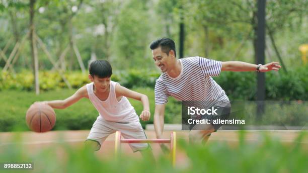 Asian Father Son Playing Basketball In Garden In Morning Stock Photo - Download Image Now