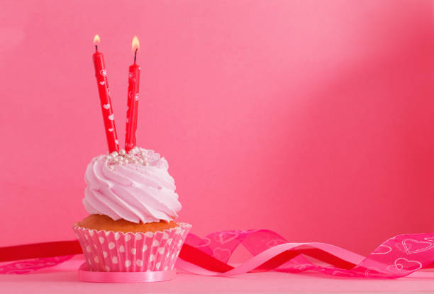 istock cupcake with candle on pink background 898853286