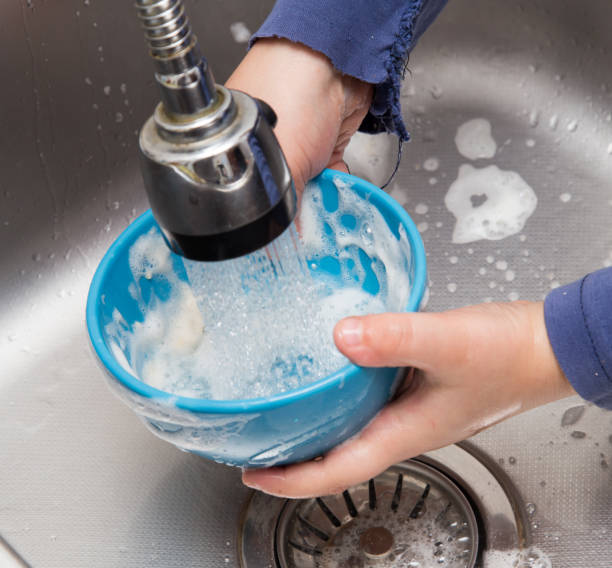 istock boy washing dishes in the kitchen 898853312
