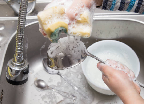 istock boy washing dishes in the kitchen 898853362