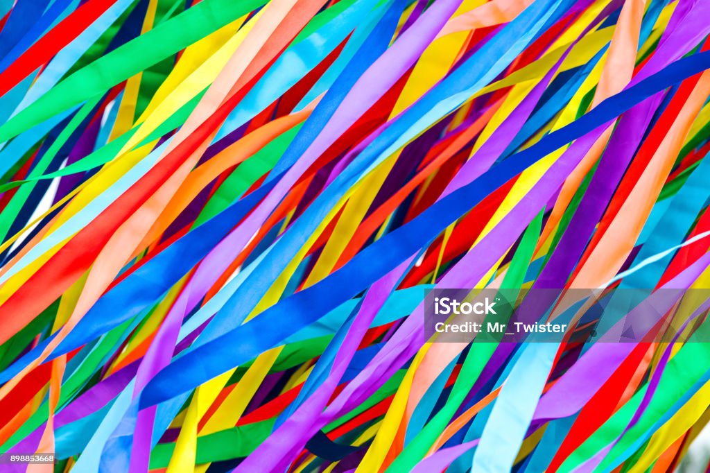 long multicolored ribbons is fluttering in the wind. festive background. long multicolored ribbons is fluttering in the wind. festive colorful background. Multi Colored Stock Photo