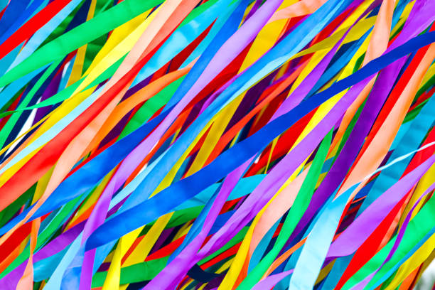 long multicolored ribbons is fluttering in the wind. festive background. long multicolored ribbons is fluttering in the wind. festive colorful background. sewing item photos stock pictures, royalty-free photos & images