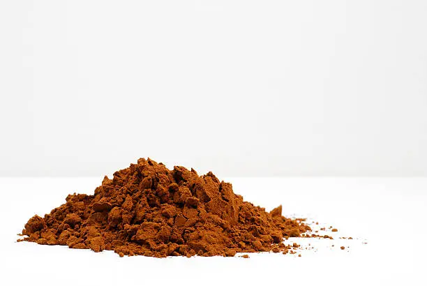 Brown cocoa powder against a white background