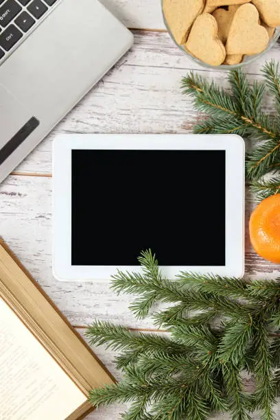 Computer tablet. Notebook. Spruce branch. Bright mandarins.