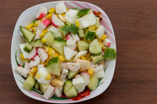 istock Salad with crab sticks, sweet corn, cucumber and eggs on wooden table 898868188