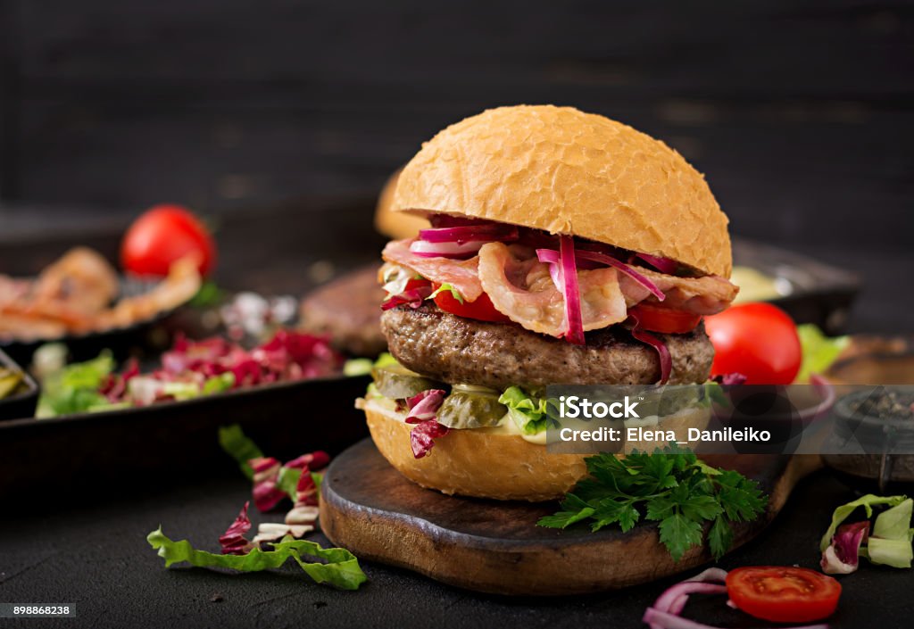 Big sandwich - burger hamburger avec du boeuf, tomate, concombre mariné et lard frit - Photo de Burger libre de droits