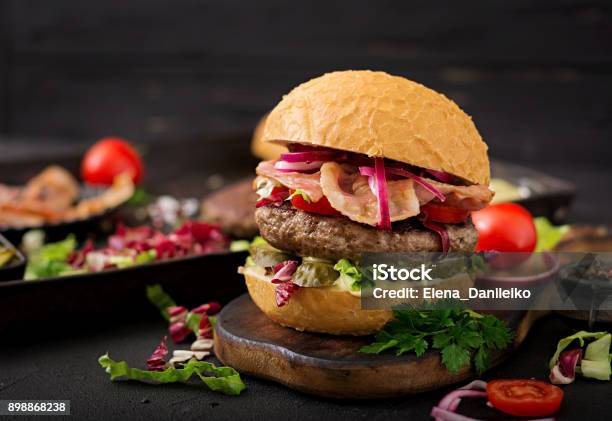 Photo libre de droit de Big Sandwich Burger Hamburger Avec Du Boeuf Tomate Concombre Mariné Et Lard Frit banque d'images et plus d'images libres de droit de Burger