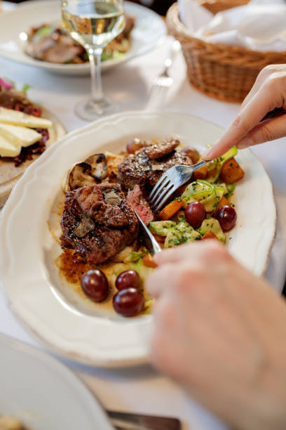 istock Woman eating steak in fine dinning restaurant 898868864