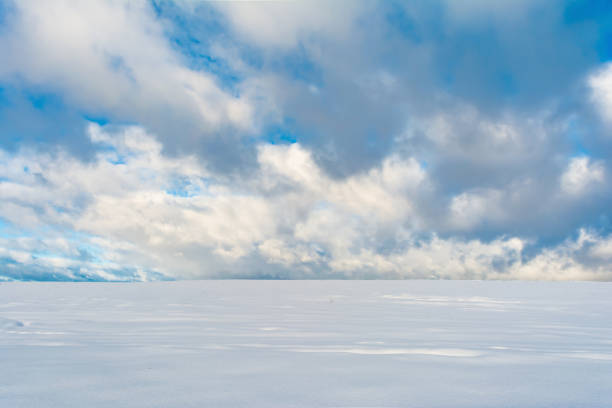 istock winter snowfield and cloudy sky with large clouds, winter nature 898869554