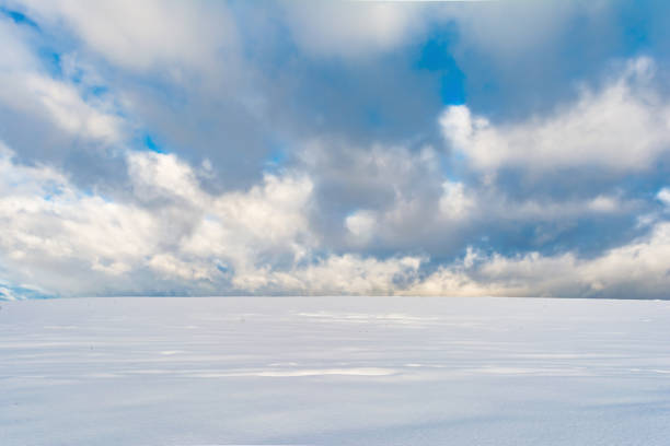 istock winter snowfield and cloudy sky with large clouds, winter nature 898869562
