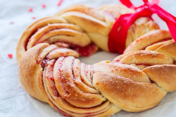 Raspberry jam swirl brioche wreath on a wooden background.