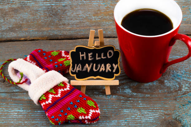 Concept HELLO january message on blackboard with a Cup of coffee and mittens stock photo