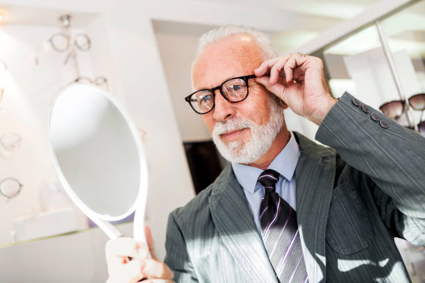 istock Senior man choosing wearing glasses in optical store 898884886