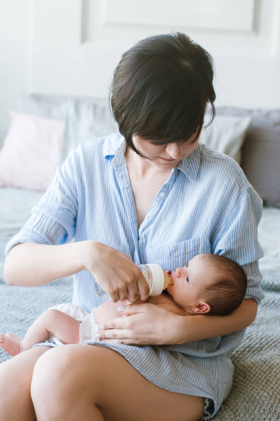 istock feeding the newborn with a mixture in a bottle 898886268