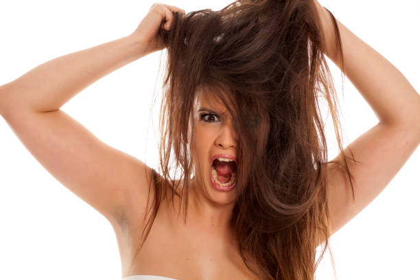 istock Angry young woman pulls her hair on white background 898898868