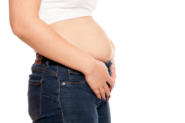 istock the woman shows her stomach that has risen from overeating 898898918