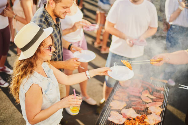 istock Group of people standing around grill. 898899192