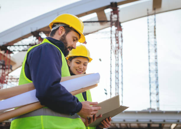 istock Team of architects revising blueprints and project implementation on construction site 898906144