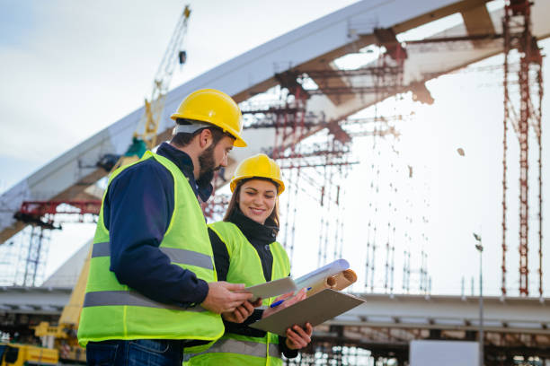 istock Large construction site with new bridge and engineers in the field 898906598