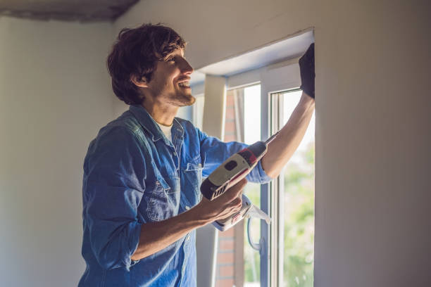 istock Man in a blue shirt does window installation 898907278