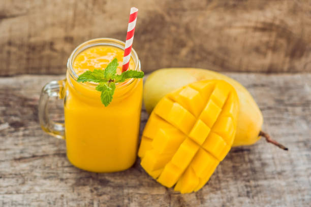 istock Healthy ripe Yellow Mango Smoothie, Mango fruit and mango cubes on the wooden table, concept healthy food 898908120