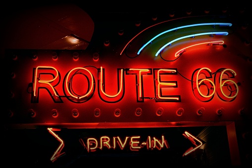 Historic Route 66. It is a neon sign in red against a black night sky.